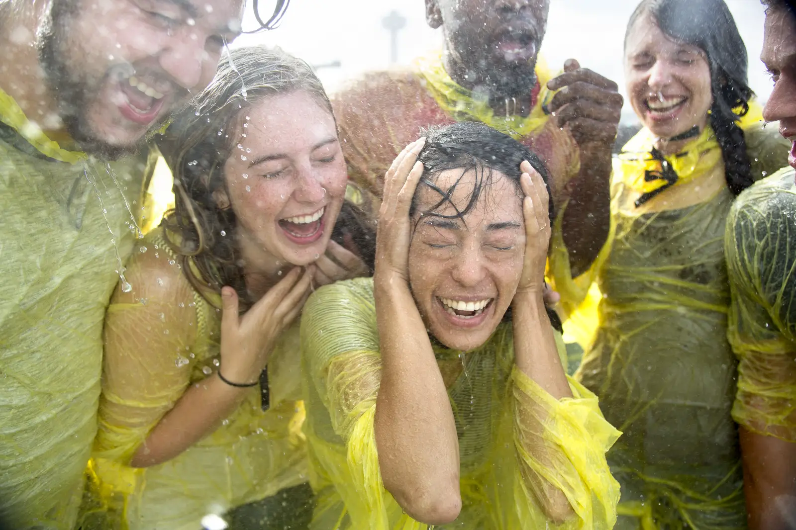 Group of friends having fun on Cave of the Winds Hurricane Deck getting wet from Bridal Veil Falls mist