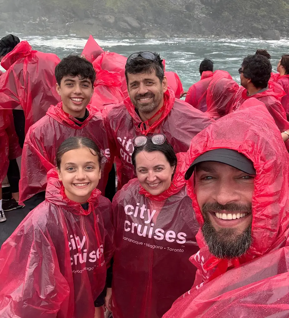 Smiling family in red ponchos on Niagara Falls boat cruise