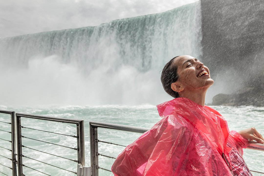 Girl enjoying the mist at Journey Behind the Falls in Niagara