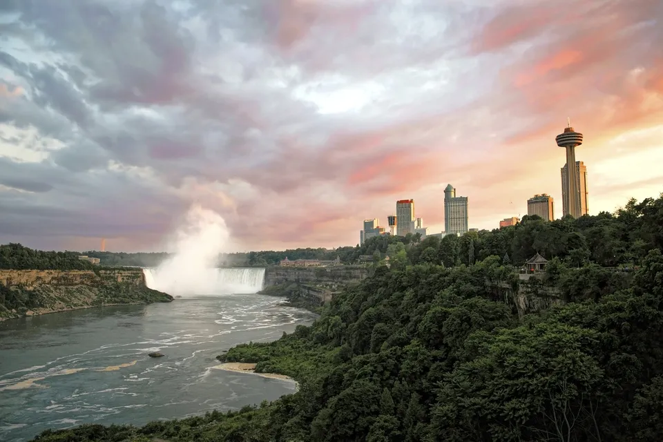 Sunset over the Canadian skyline and misty Niagara Falls