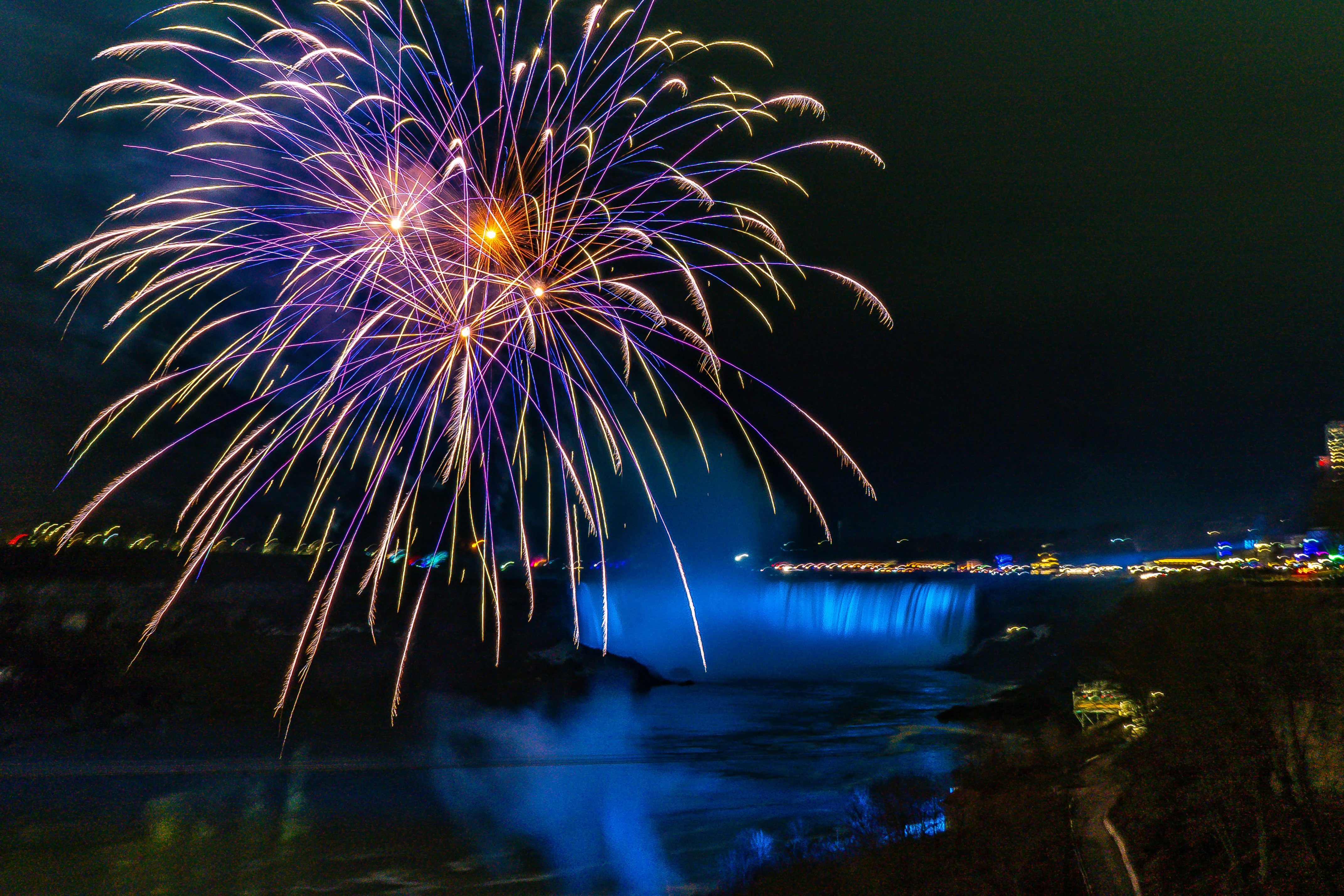 Spectacular fireworks display over illuminated Niagara Falls in winter