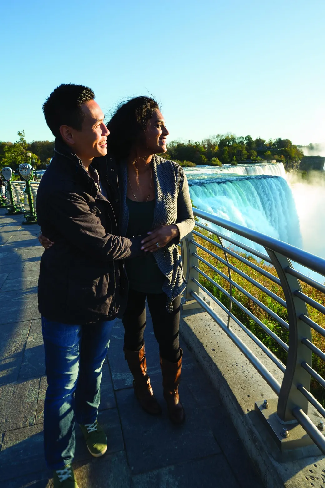 Romantic couple enjoying amazing tour date at Prospect Point overlooking Niagara Falls appearing happy and in love